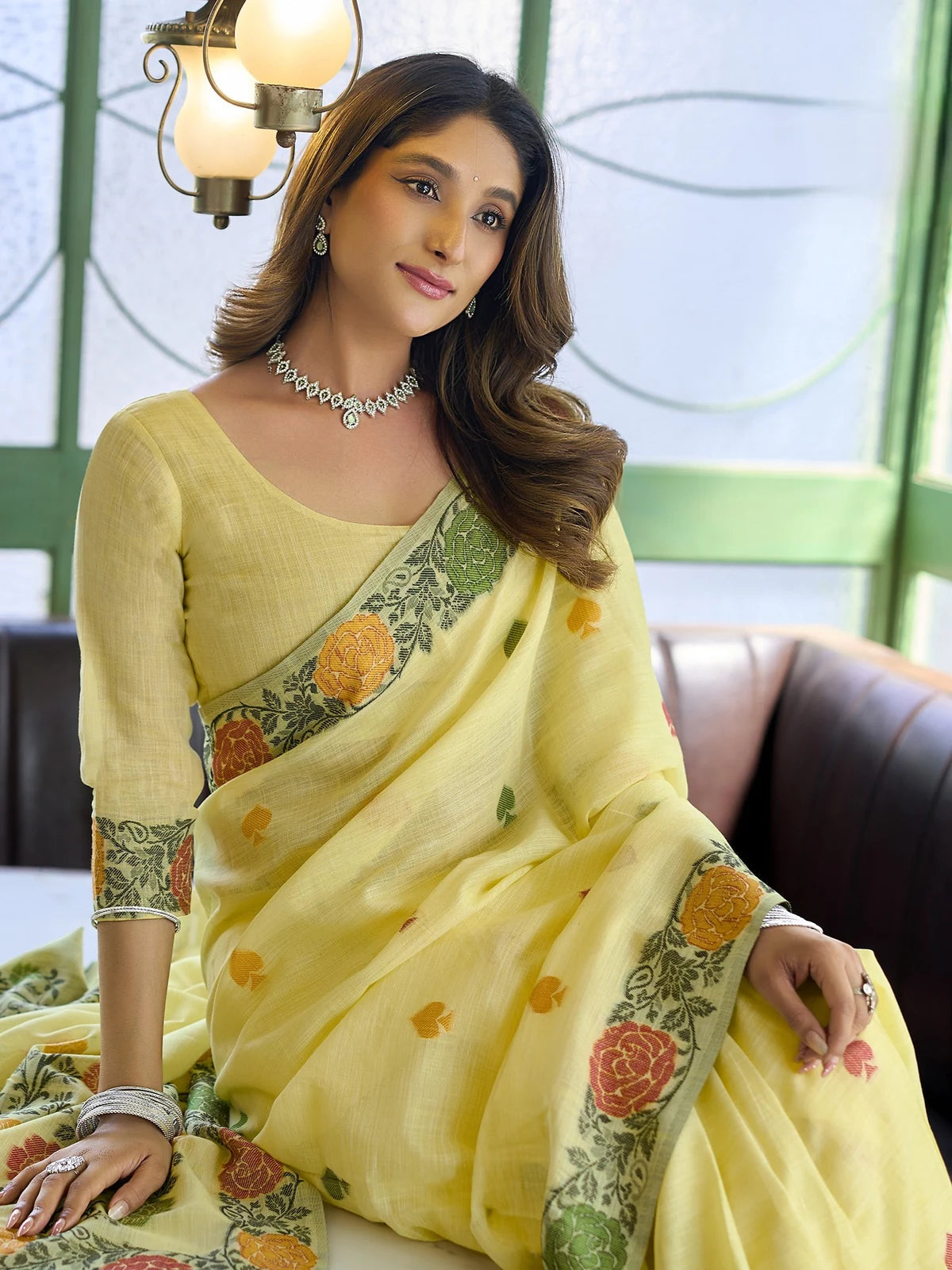 Tarani yellow linen handloom saree closeup view with floral woven detailing and festive styling