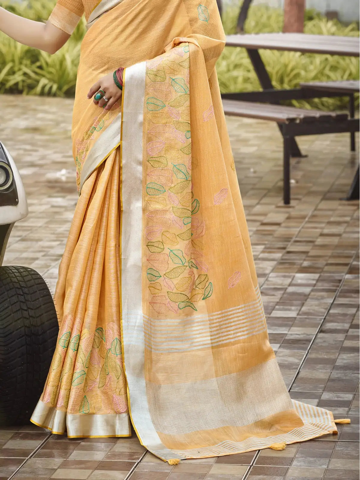 Tarani yellow linen saree pallu view with floral embroidery and silver border