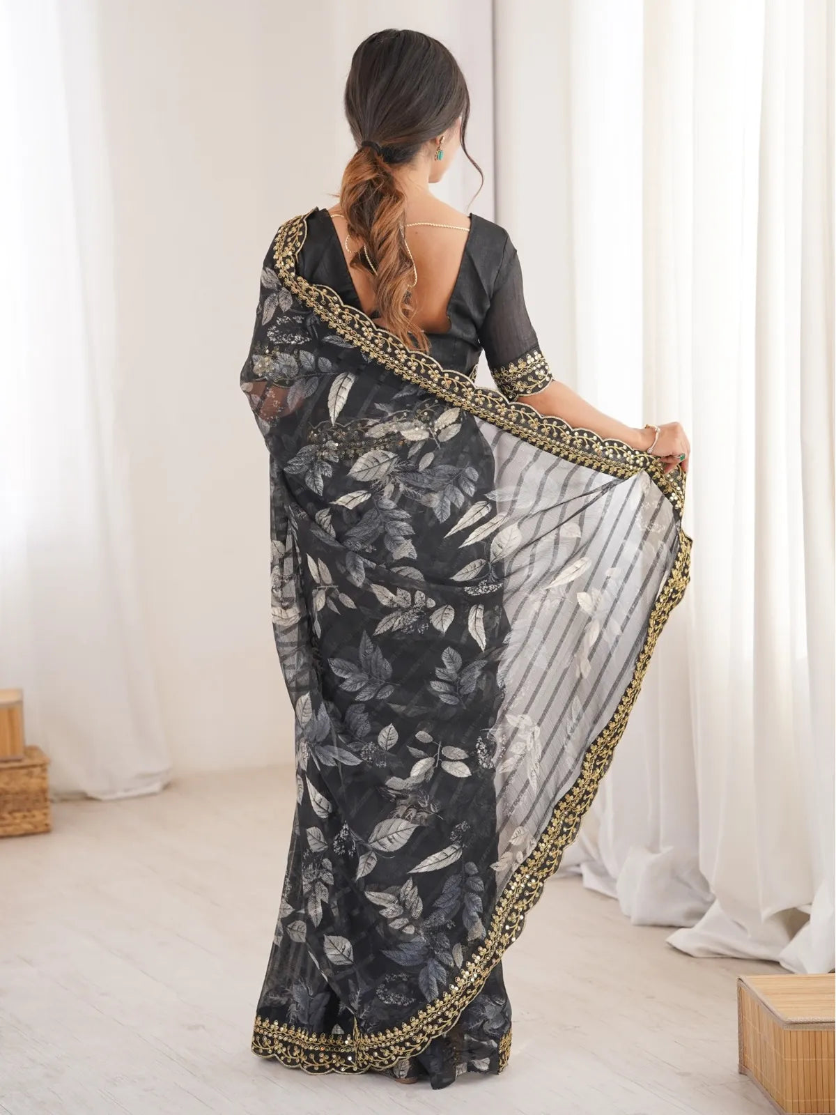 Tarani black saree back view showing blouse cut and floral pattern on chiffon pallu