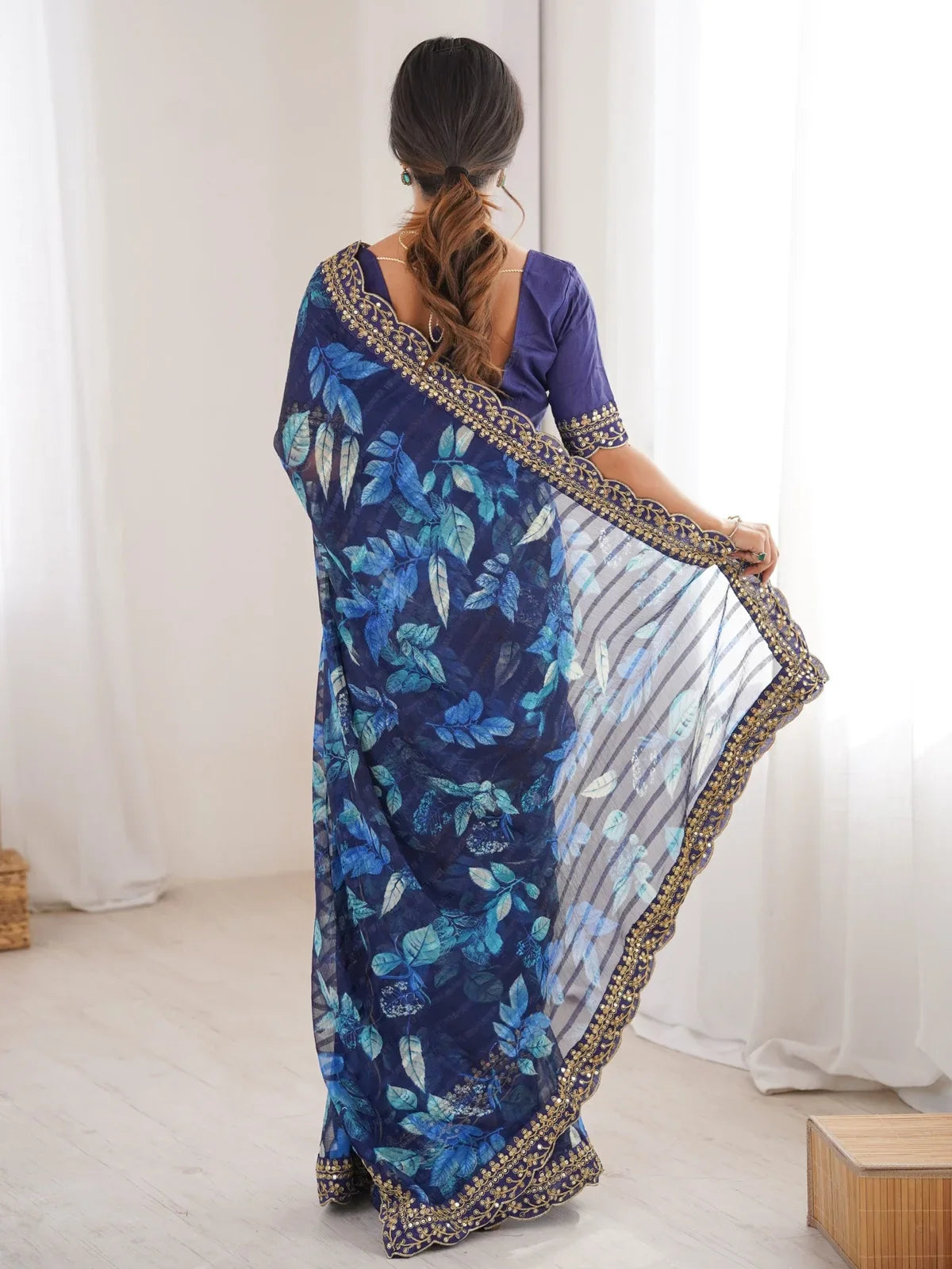 Tarani back view of floral blue saree with transparent flow and designer scallop border