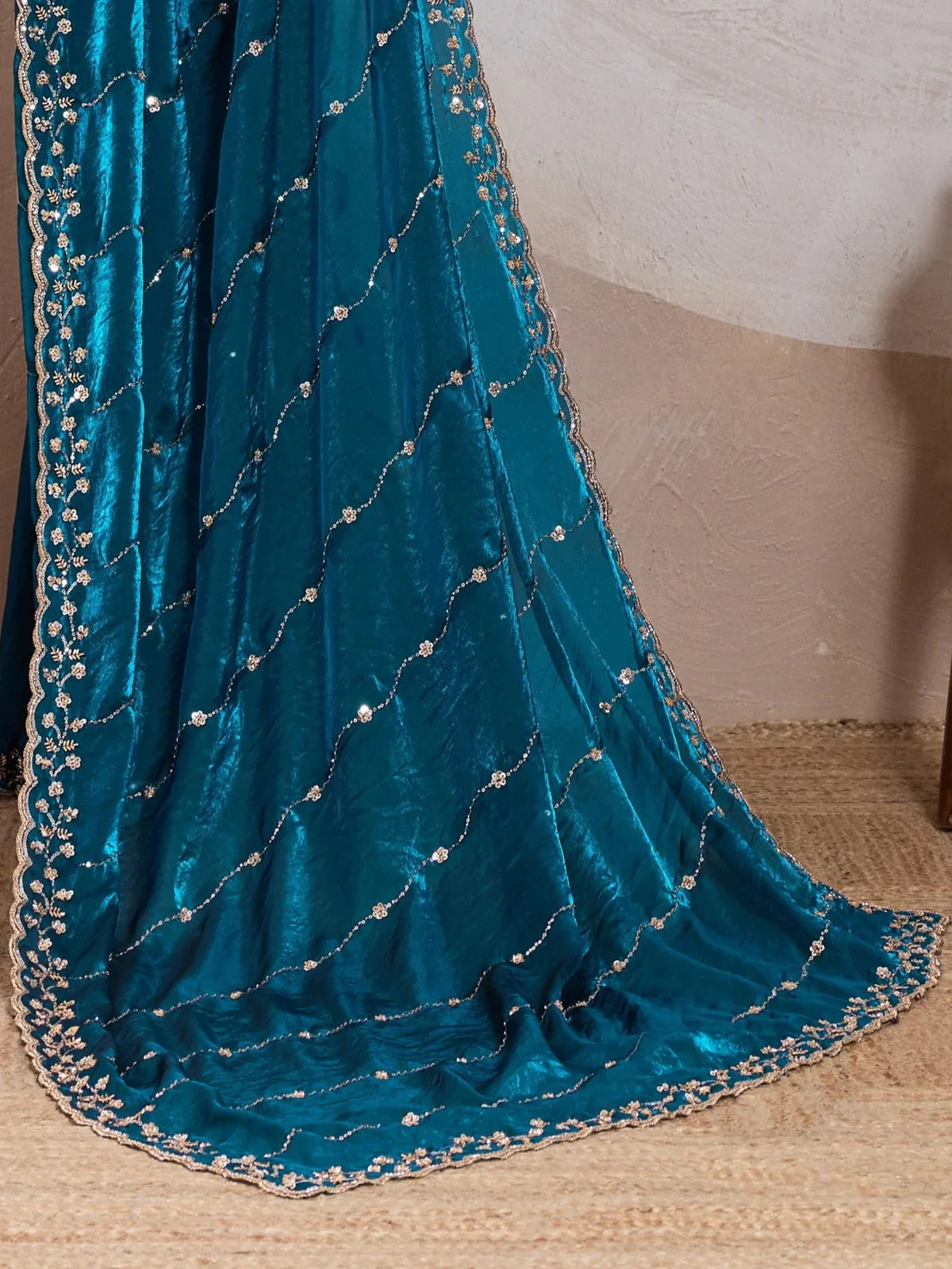 Close-up of Tarani metallic velvet satin green saree fabric and intricate hand embroidery