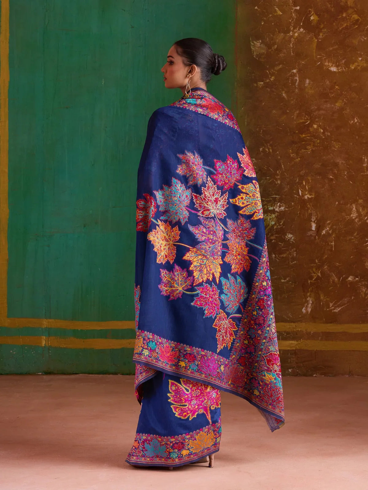 Tarani elegant navy blue saree with full pallu view showcasing colorful leaf design and intricate border work, back view