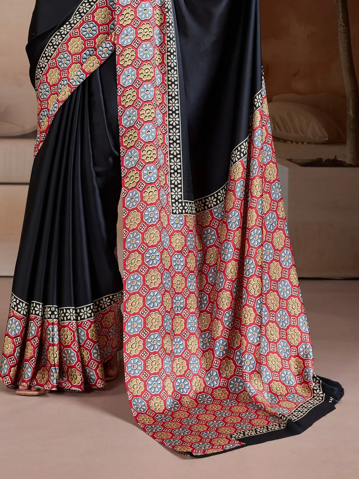 Tarani modal satin saree with geometric floral printed pallu in red yellow and blue on black base