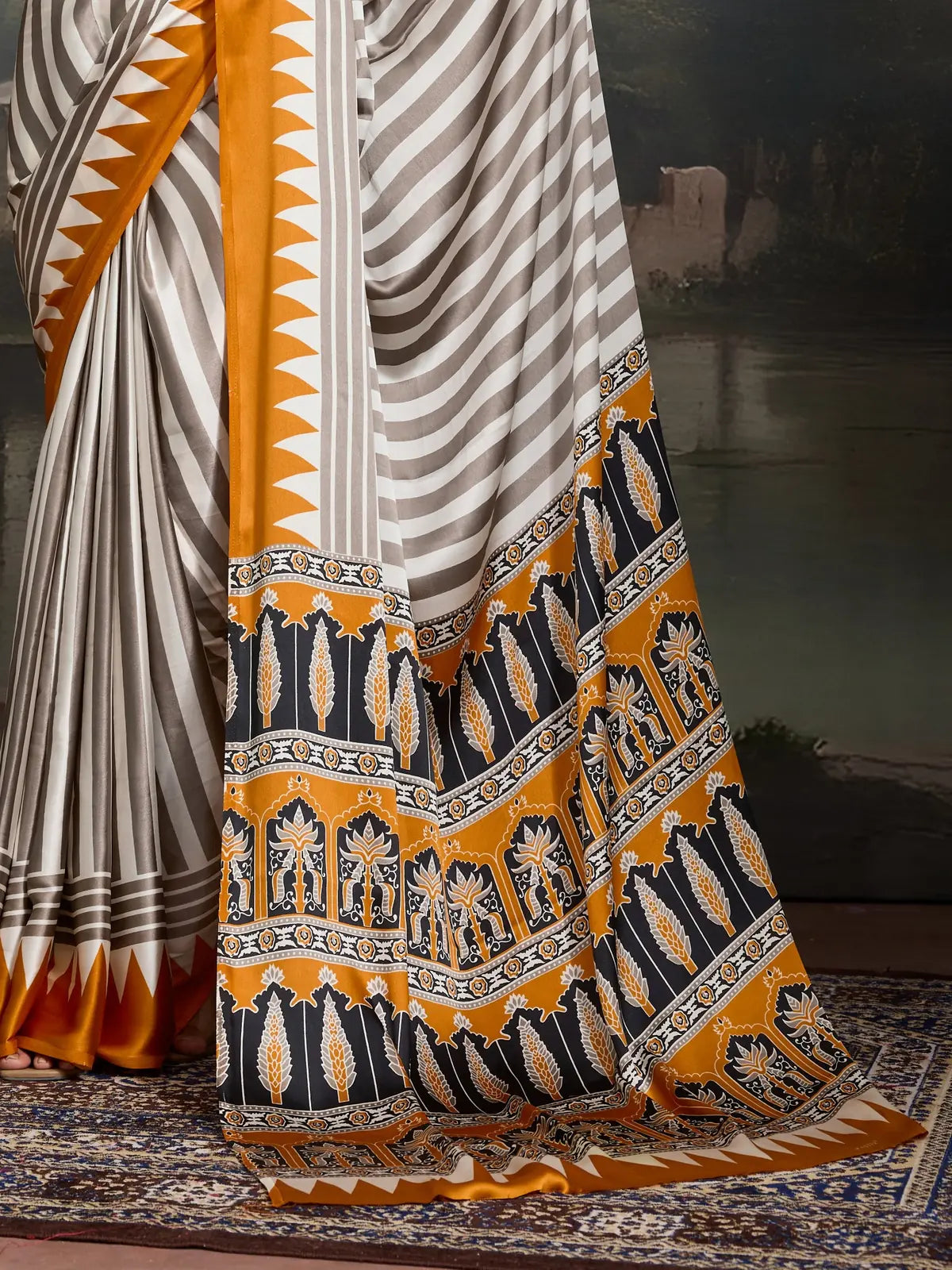 Tarani modal satin saree showcasing pallu and intricate printed border in mustard and black