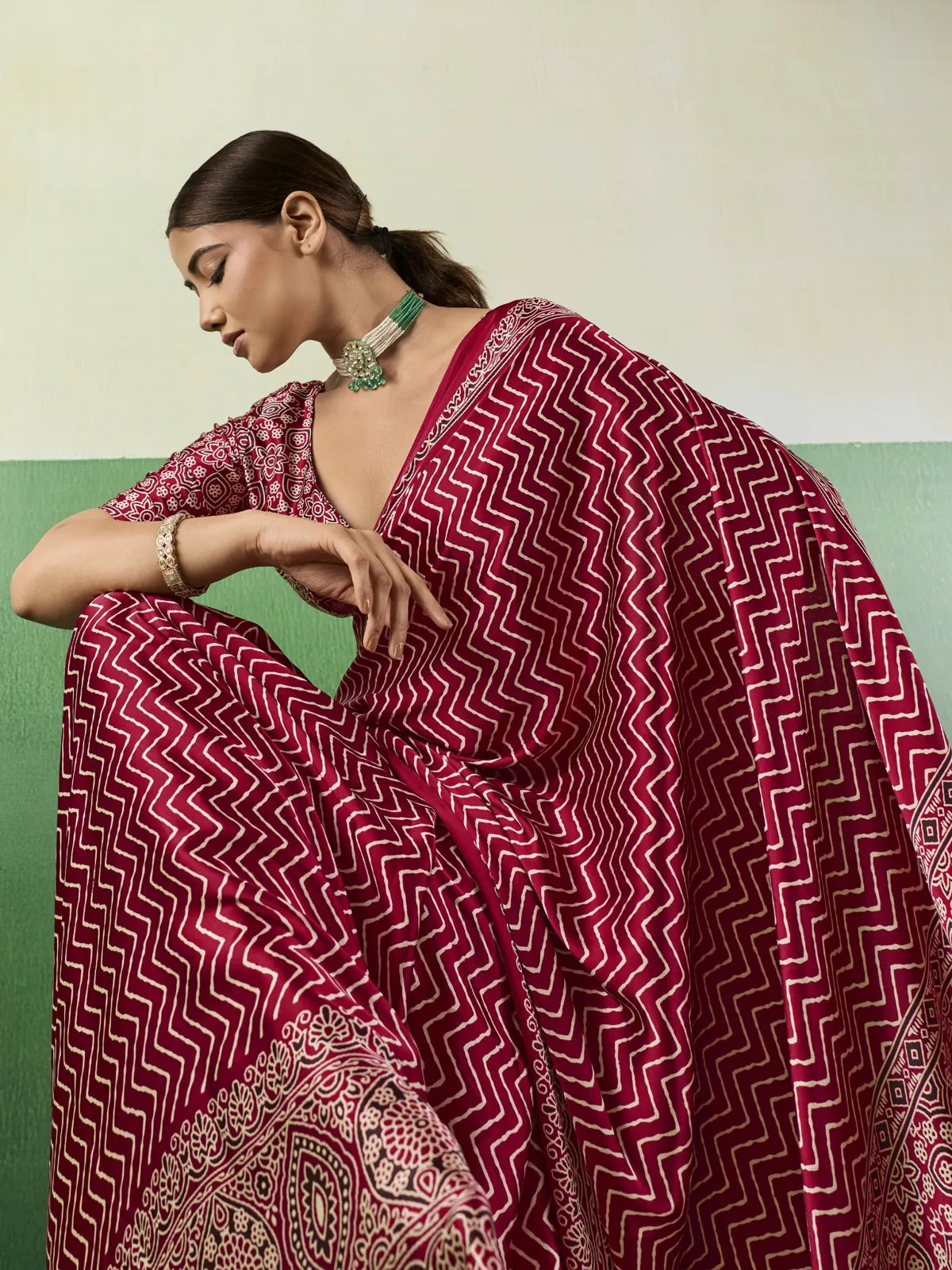 Tarani closeup view of maroon modal satin Ajrakh print saree with zigzag pattern and rich detailing