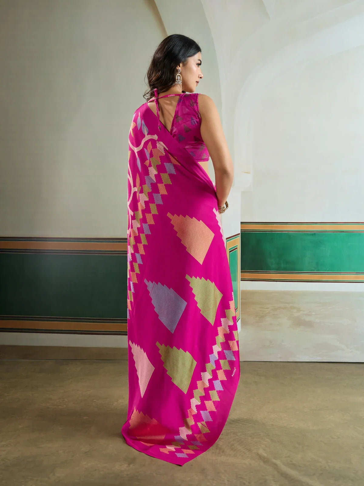 Tarani back view of model wearing modal satin pink saree with pallu and motifs draping elegantly