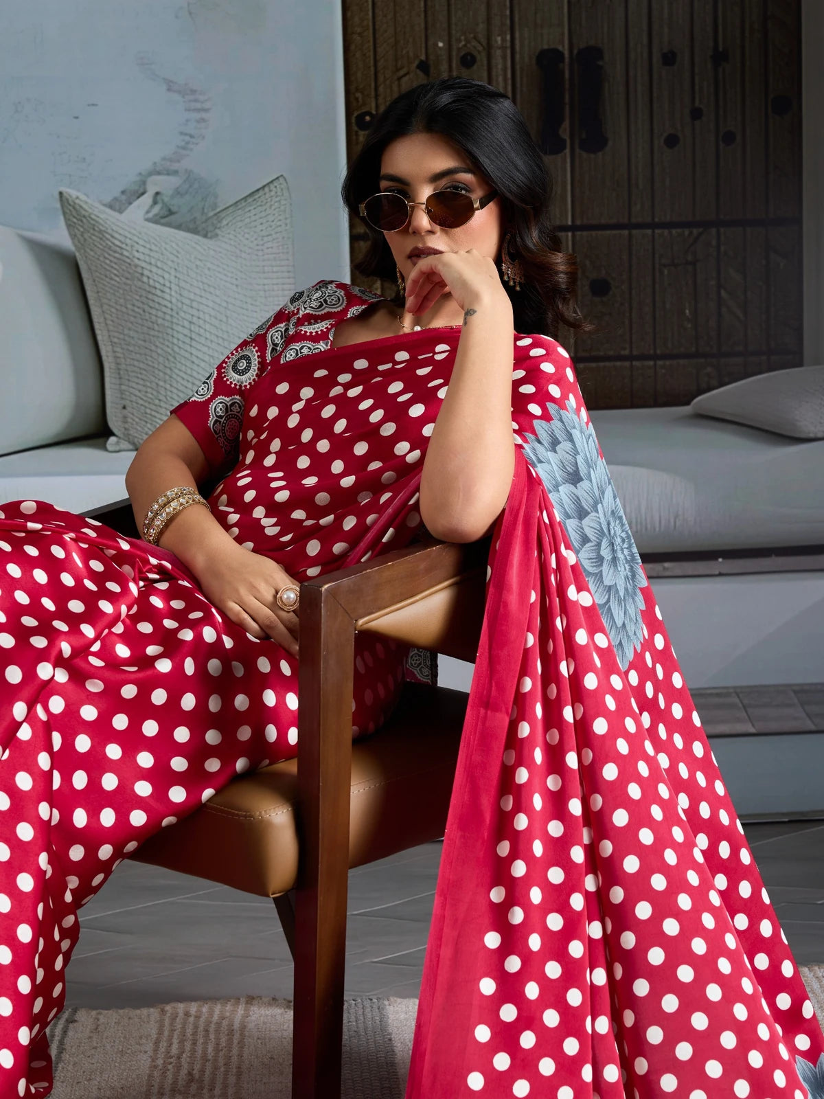 Tarani red modal satin Ajrakh print saree with elegant polka dot pallu seated pose