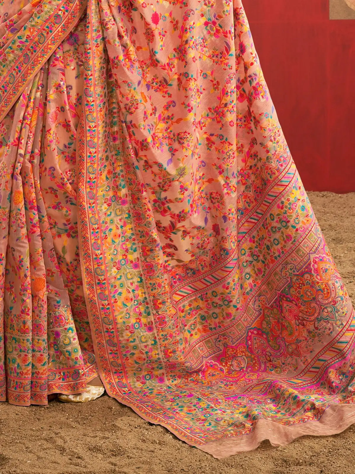 Tarani peach saree closeup showing vibrant multicolor floral weaving and soft cotton texture