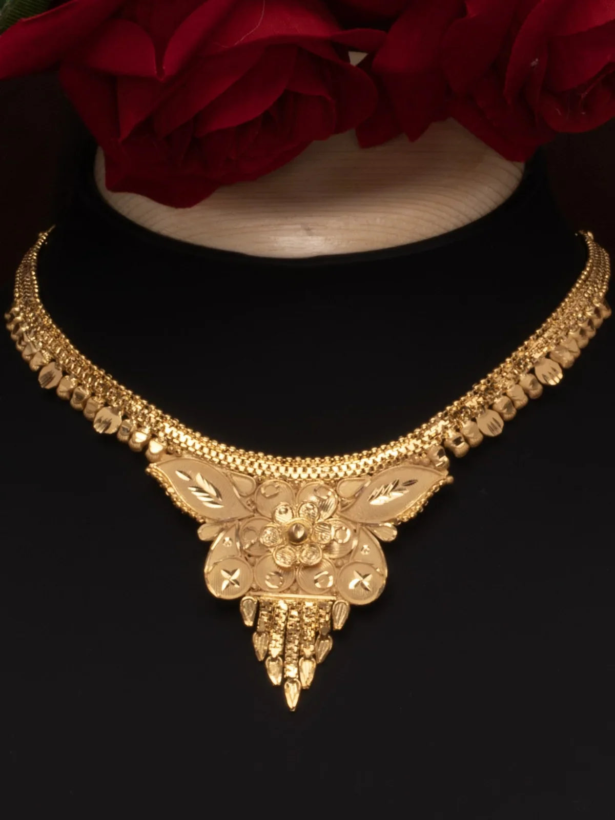 Tarani closeup view of gold plated necklace with floral detailing for festive occasions