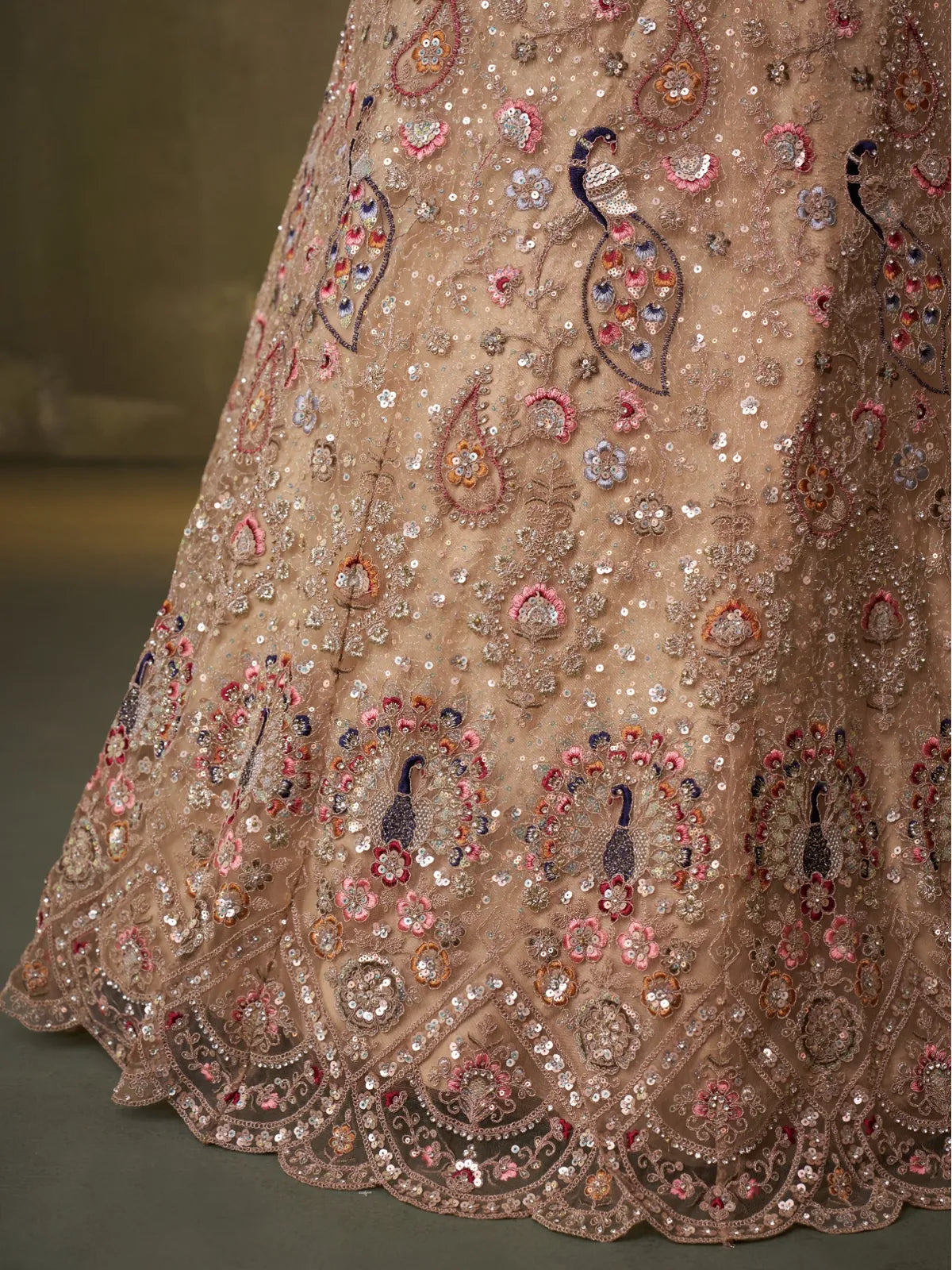 Tarani lehenga closeup showing peacock embroidery and multi-sequins on beige net fabric