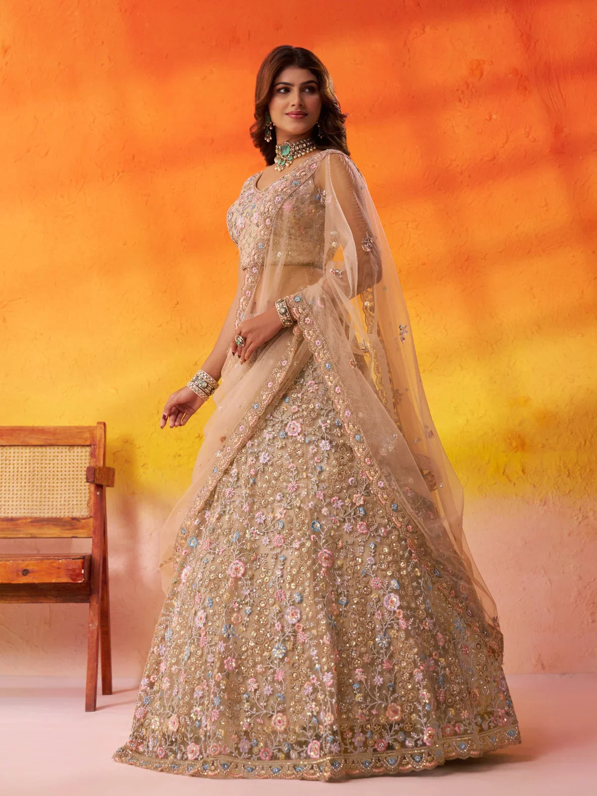 Front view of Tarani beige net lehenga with sequin detailing and full flare embroidery work
