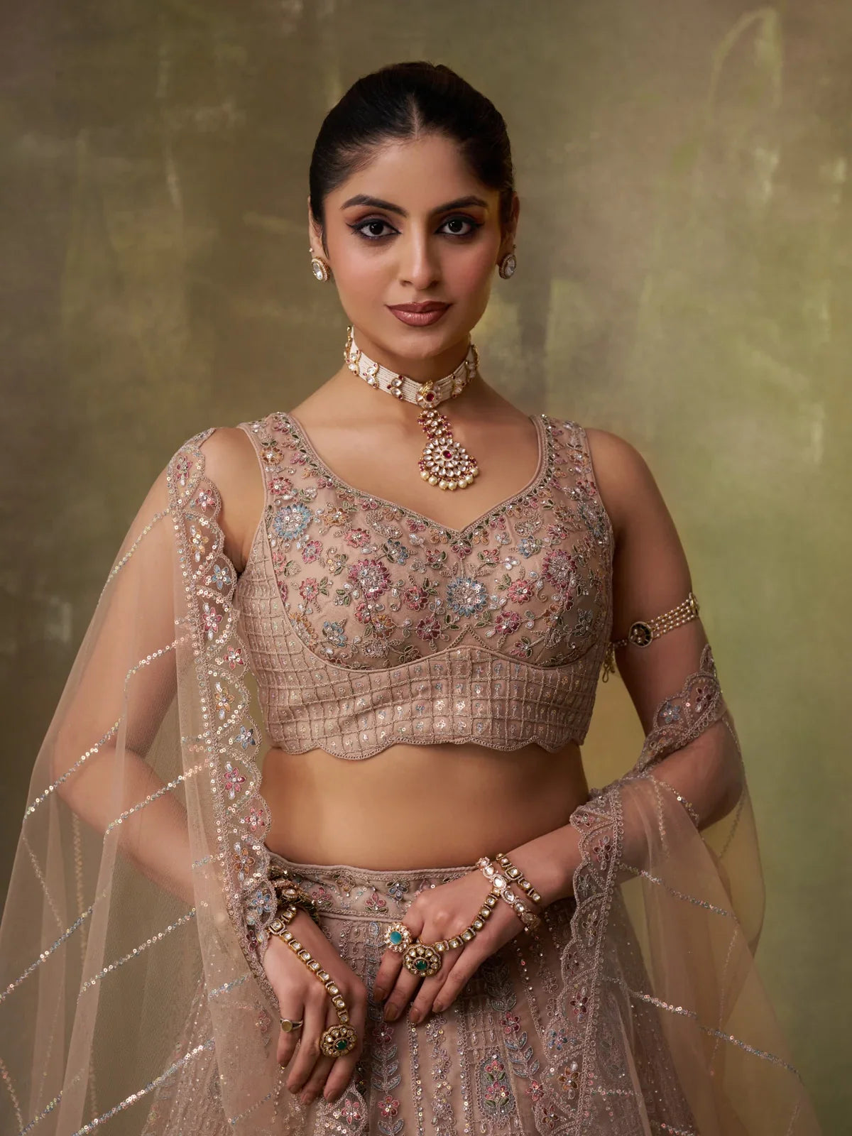 Tarani beige net lehenga close-up of blouse with ethnic jewellery and detailed embroidery