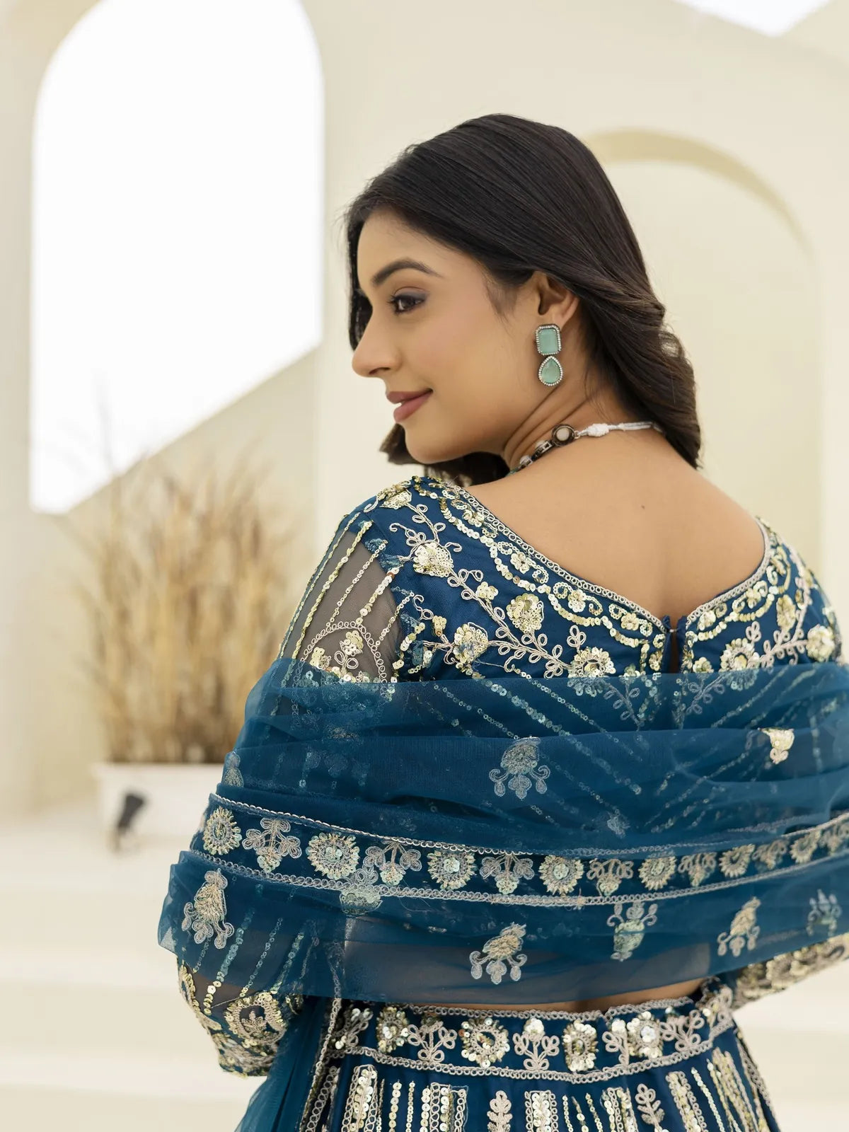 Tarani blue net lehenga back view with detailed floral embroidery and dupatta draped over shoulder