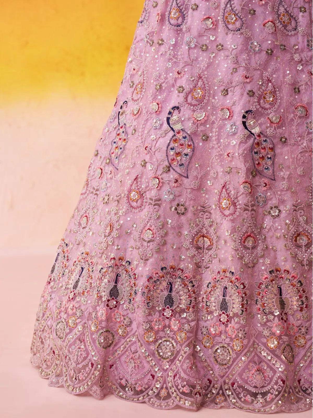 Tarani pink net lehenga closeup showing mirror, thread, and coding work with floral and peacock patterns