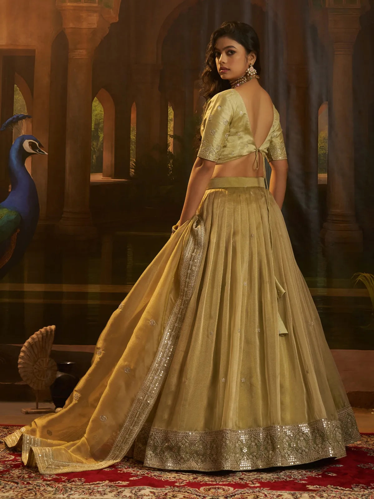 Tarani golden organza lehenga back view with deep back blouse and elegant drape styling
