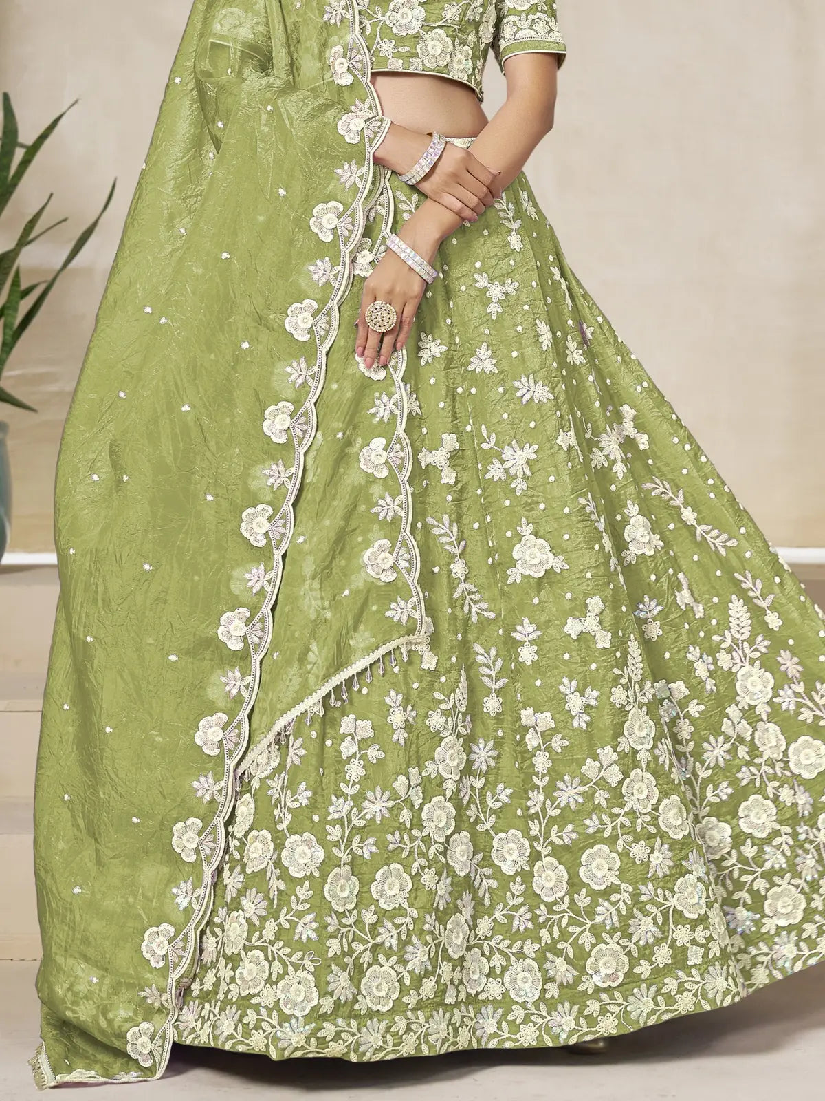 Tarani green organza lehenga closeup view highlighting fine floral embroidery and fabric texture