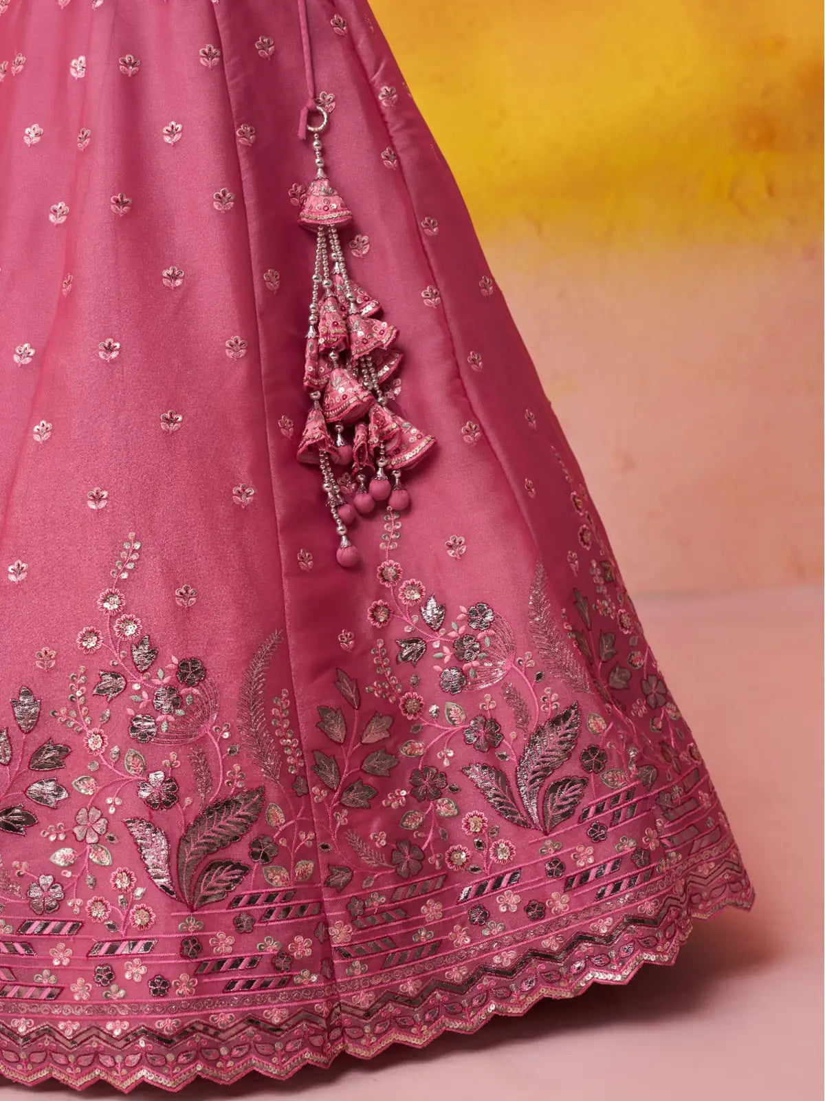 Tarani lehenga closeup showcasing tassels, mirror work, and floral embroidery border