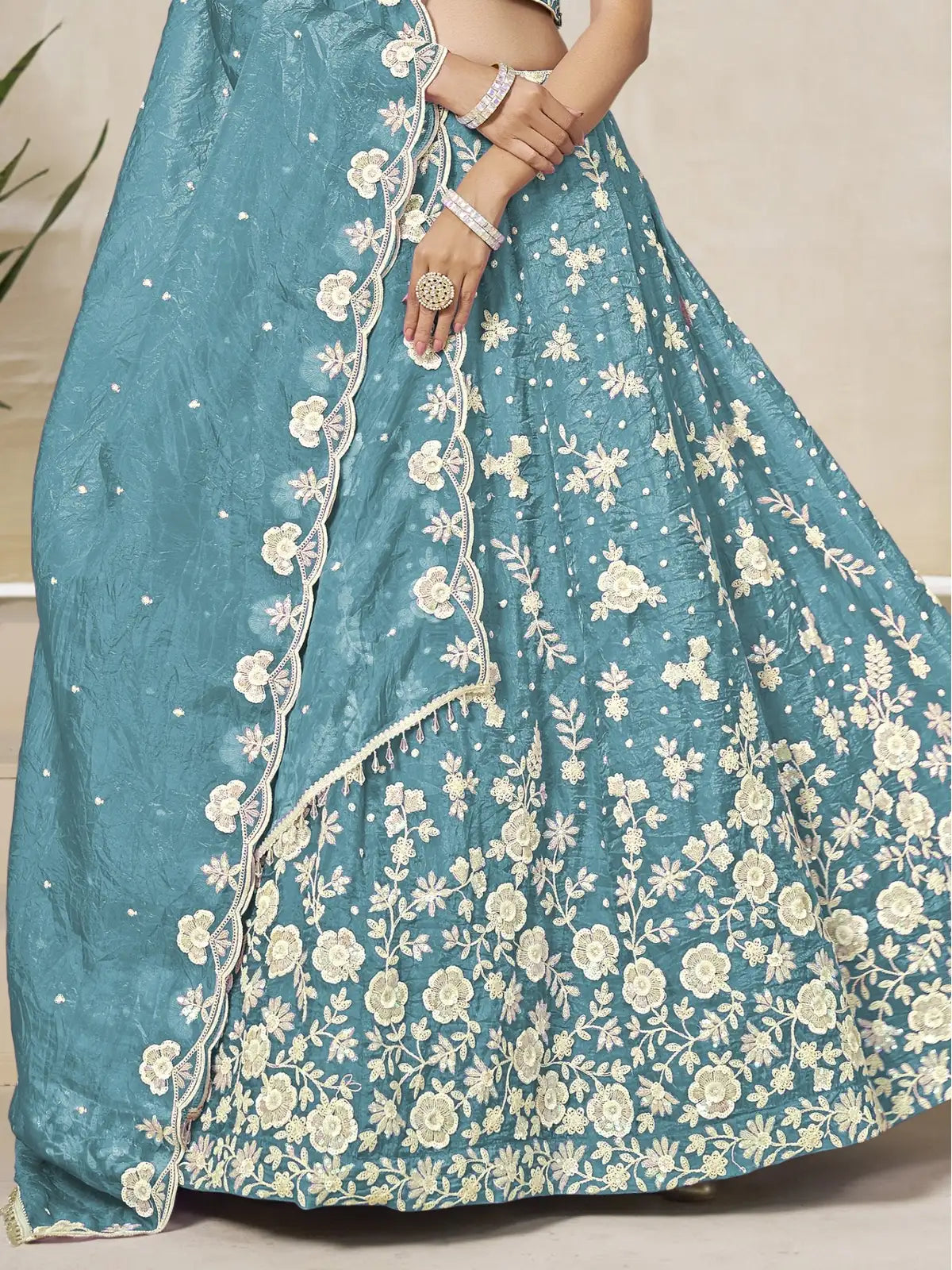 Tarani teal organza lehenga fabric closeup highlighting floral embroidery