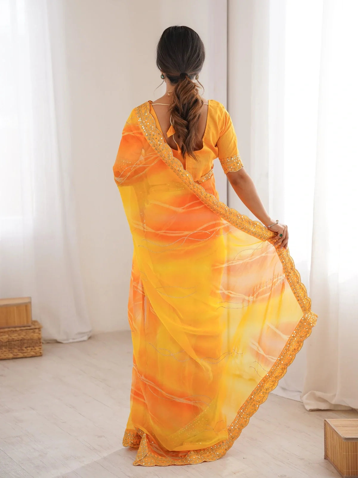 Back view of Tarani yellow chiffon saree showing pallu and blouse design in festive look
