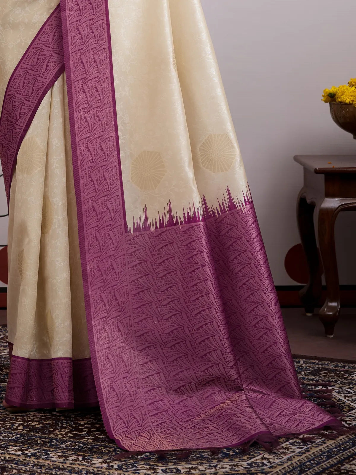 Closeup of Tarani cream paper silk saree fabric and plum woven detailing