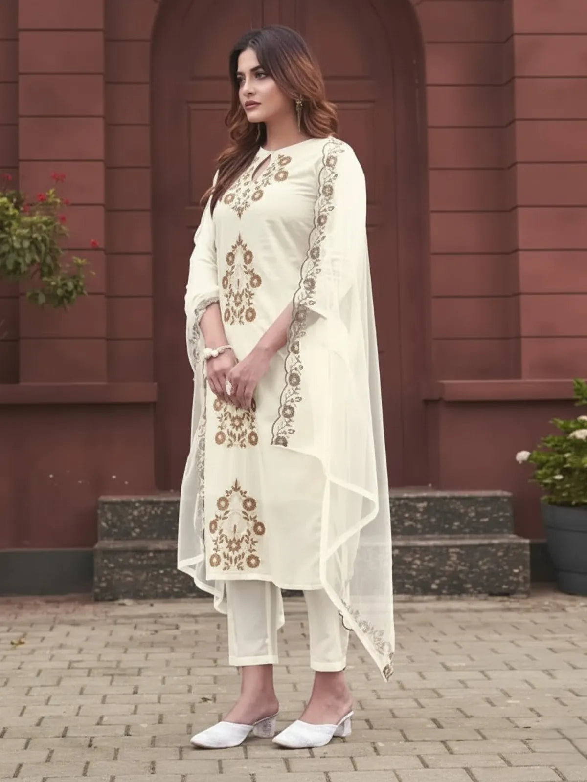 Side pose of model in Tarani off white rayon embroidered kurti set with dupatta