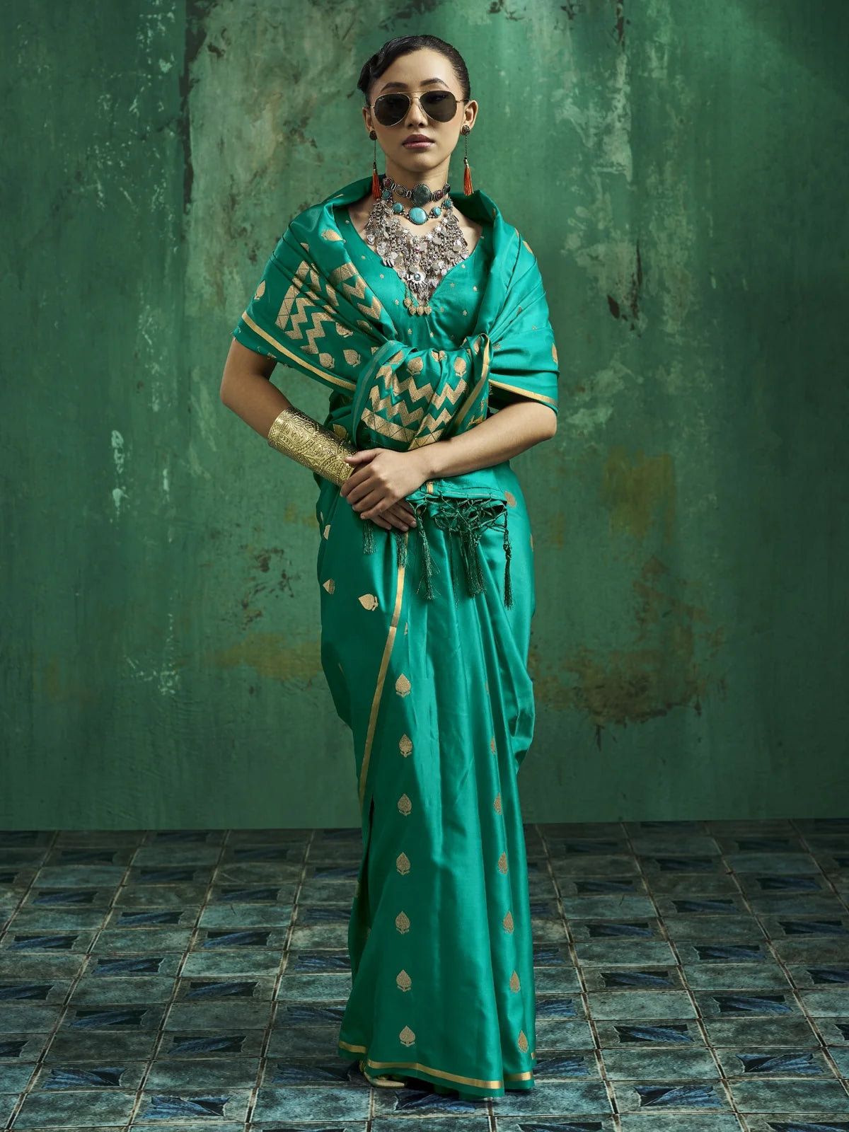 Tarani teal green satin saree front view with elegant golden motifs and festive styling