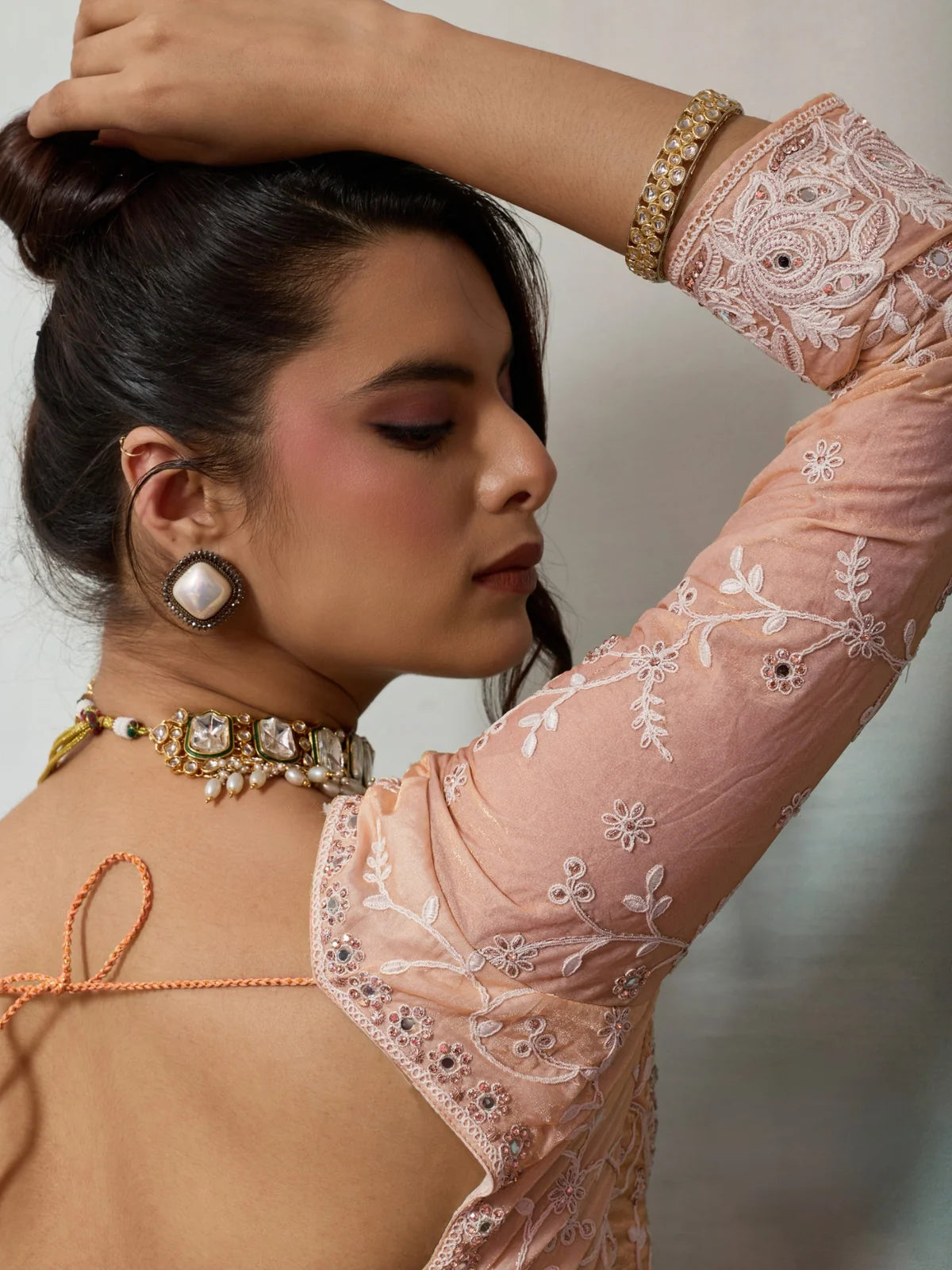 Tarani embroidered satin velvet blouse back view with handwork detailing and peach saree