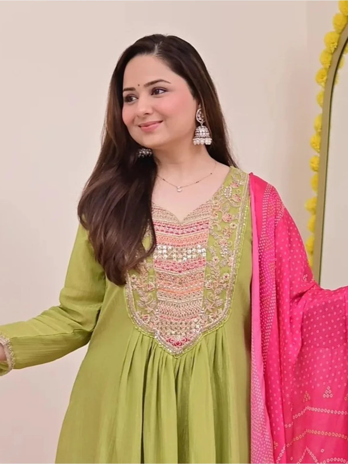 Tarani close-up of green silk dress with mirror and thread embroidery on neckline