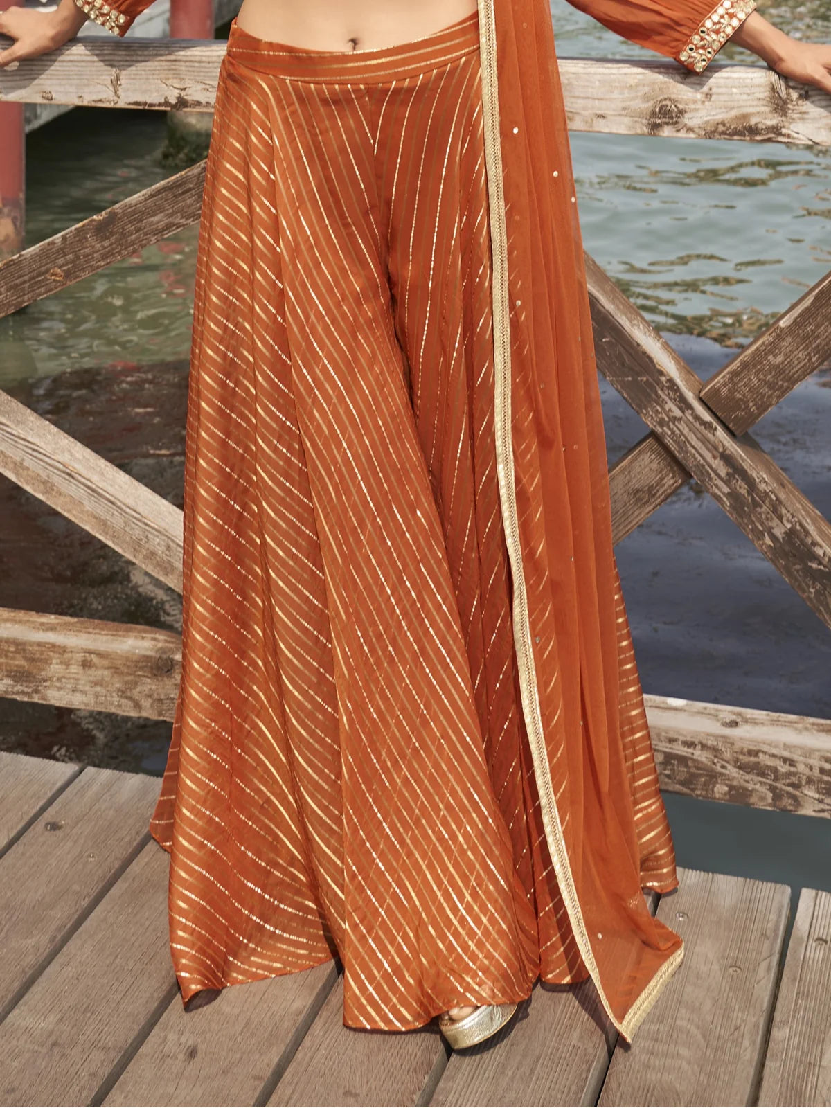 Tarani silk orange sharara closeup view highlighting fabric texture and sequin work