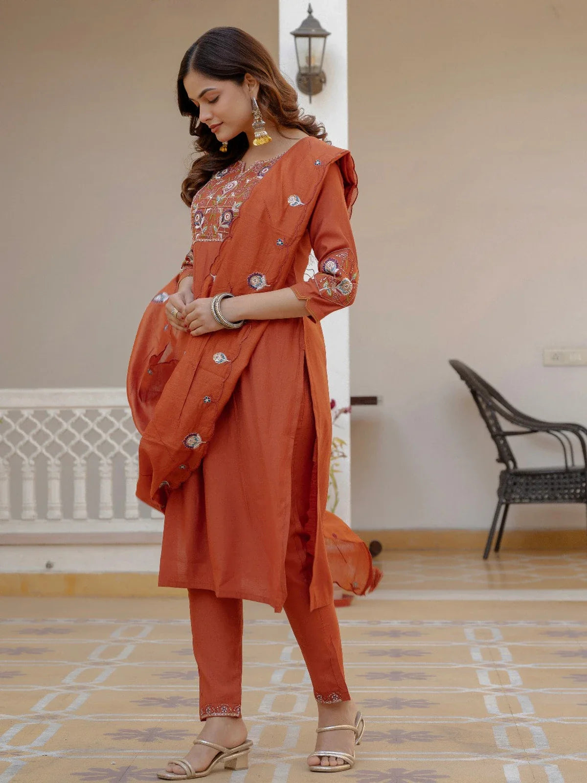 Tarani side pose of rust silk kurti set showing embroidery and elegant fall
