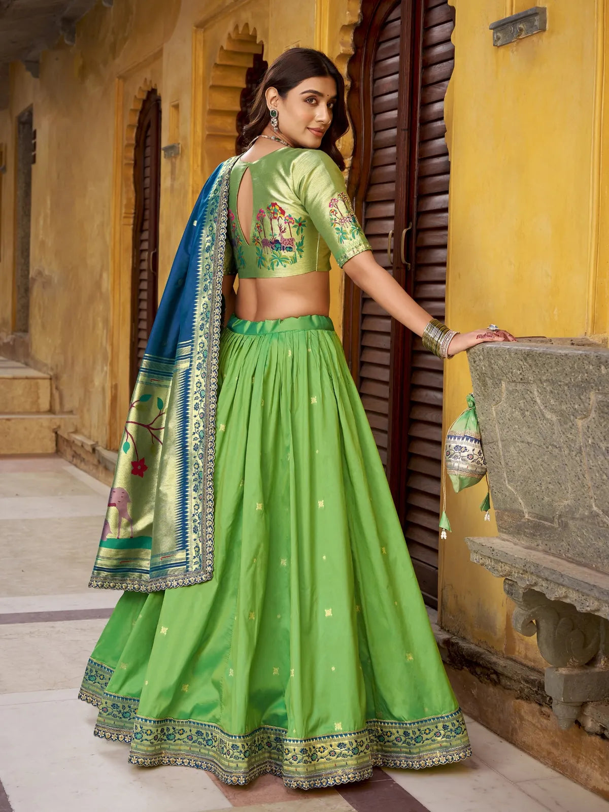 Tarani green silk lehenga back pose showing pleated flair and elegant back blouse cut