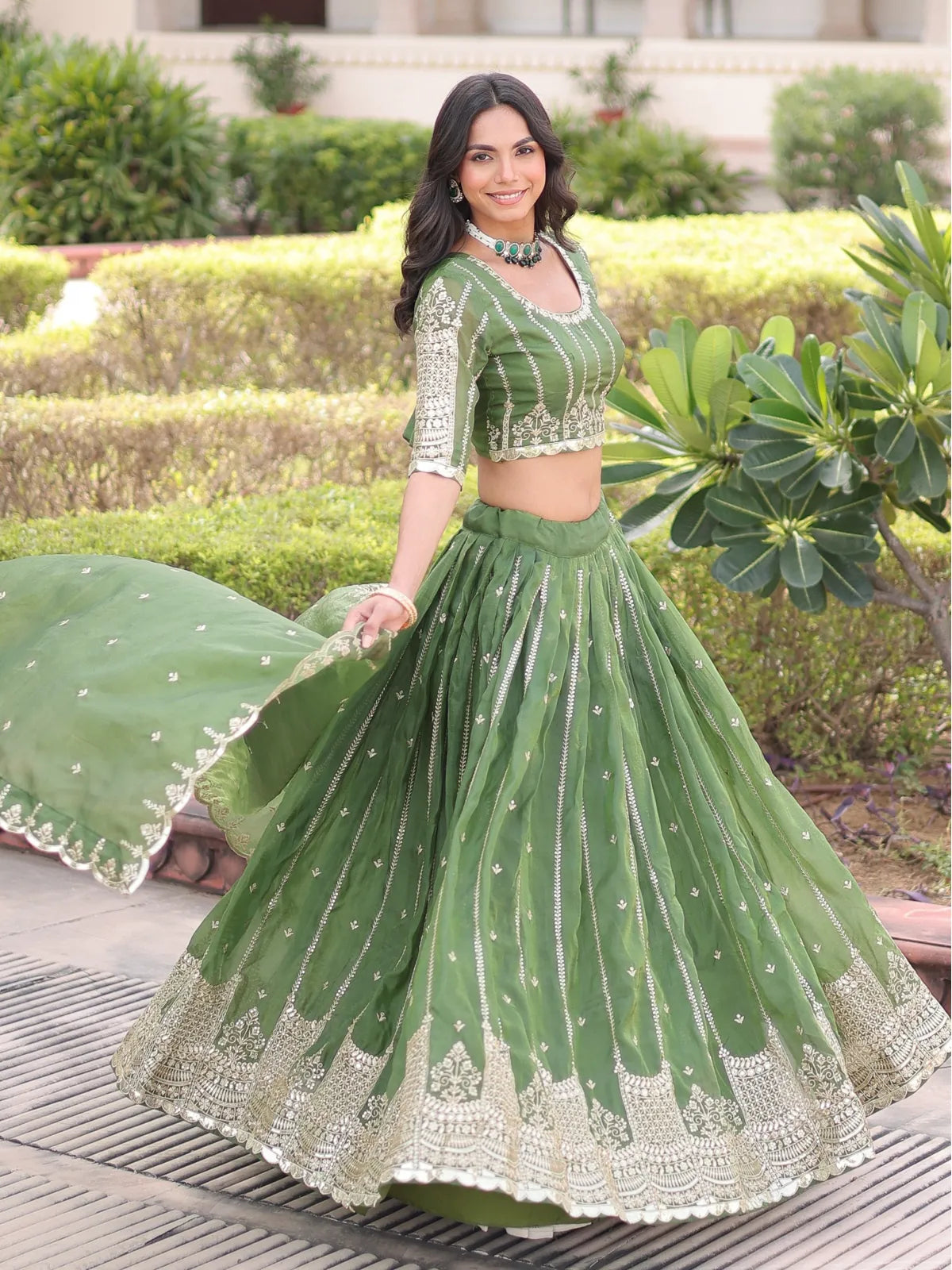 Tarani lehenga in green silk with heavy embroidery and front-facing full view drape
