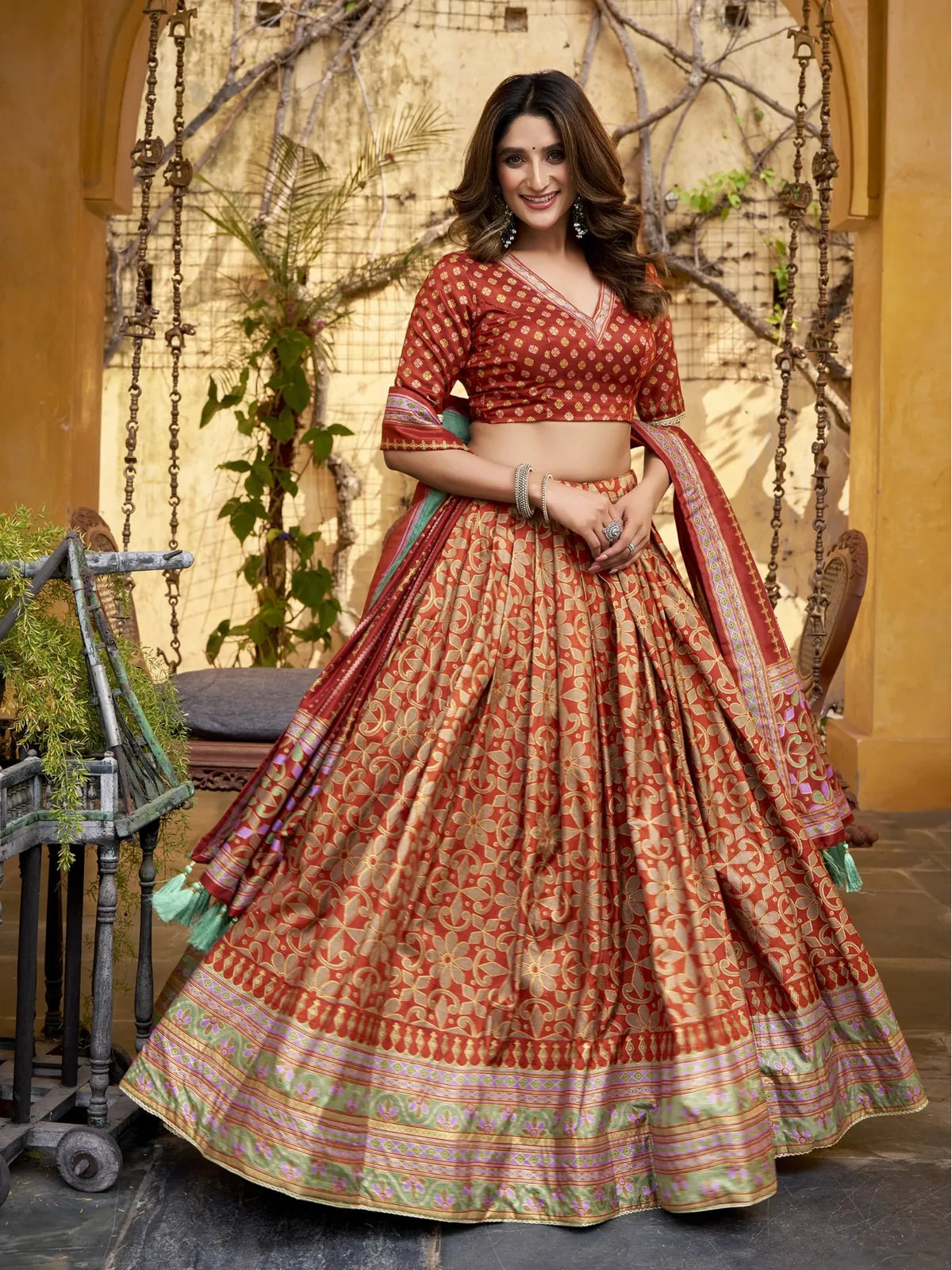 Tarani full lehenga view in maroon silk with golden motifs and green border details