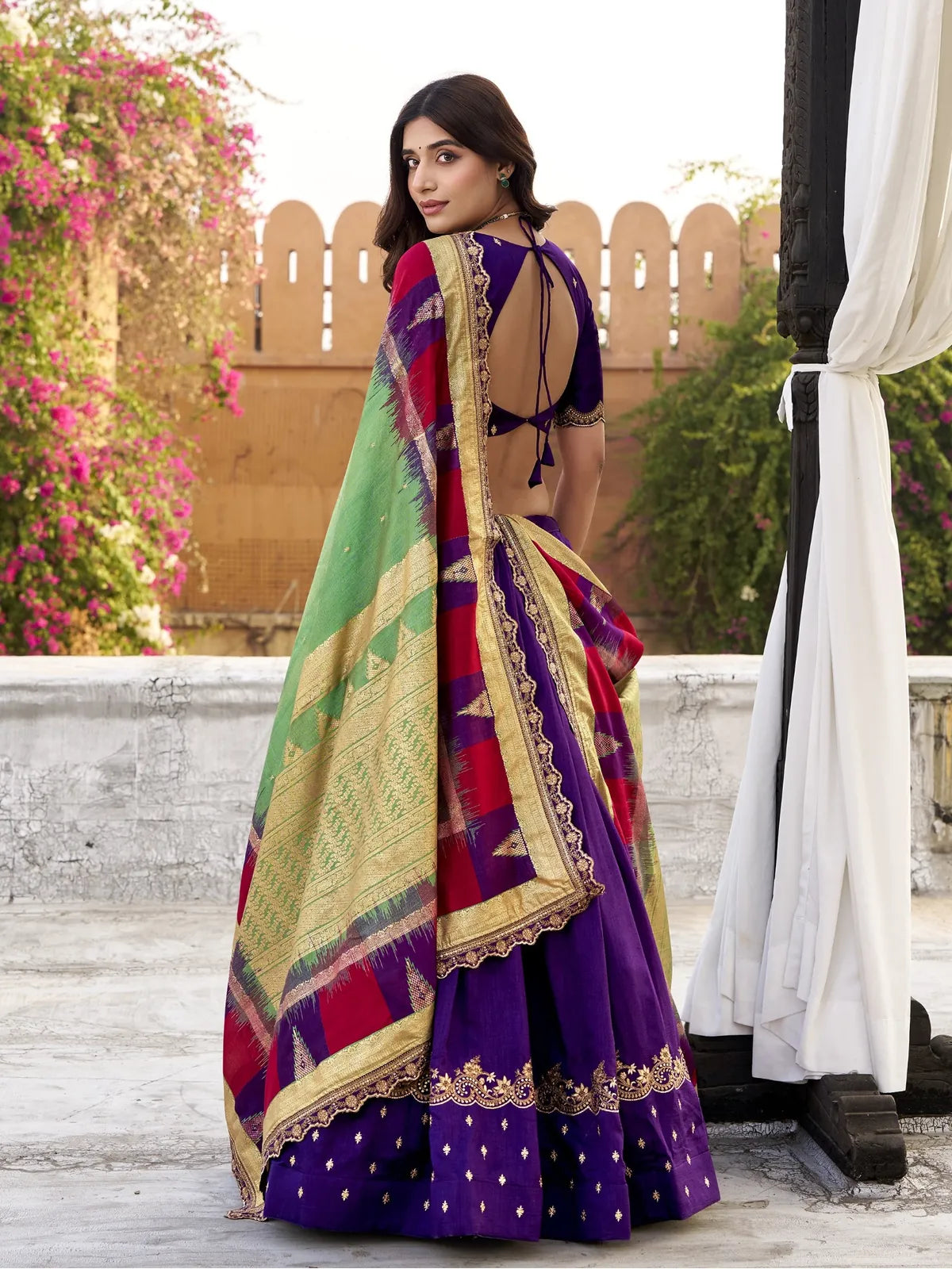 Tarani lehenga back view showing tied blouse back design and contrast dupatta with golden lace border