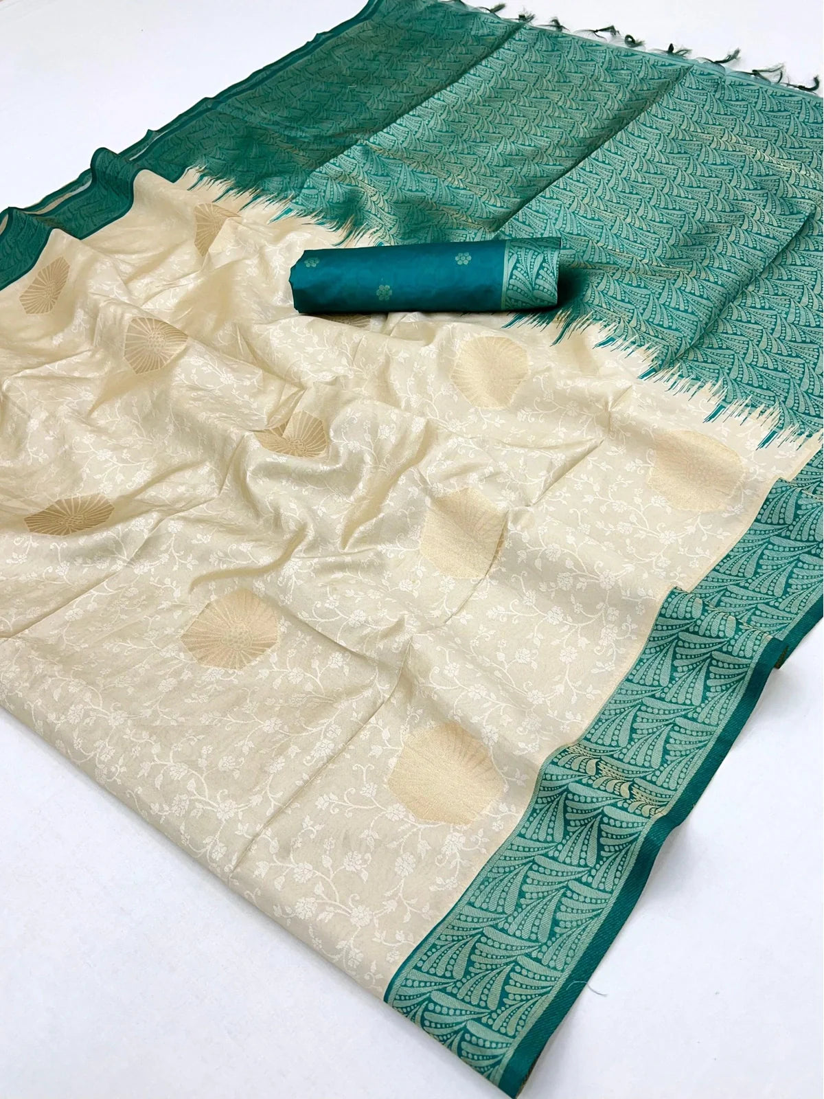 Tarani detailed fabric closeup of cream beige paper silk saree with teal border and motifs