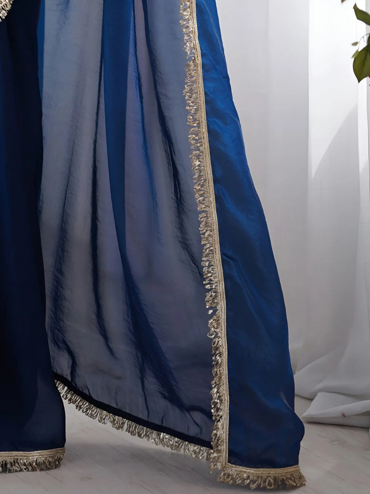 Tarani blue soft silk saree with golden lace pallu flowing gracefully in focus