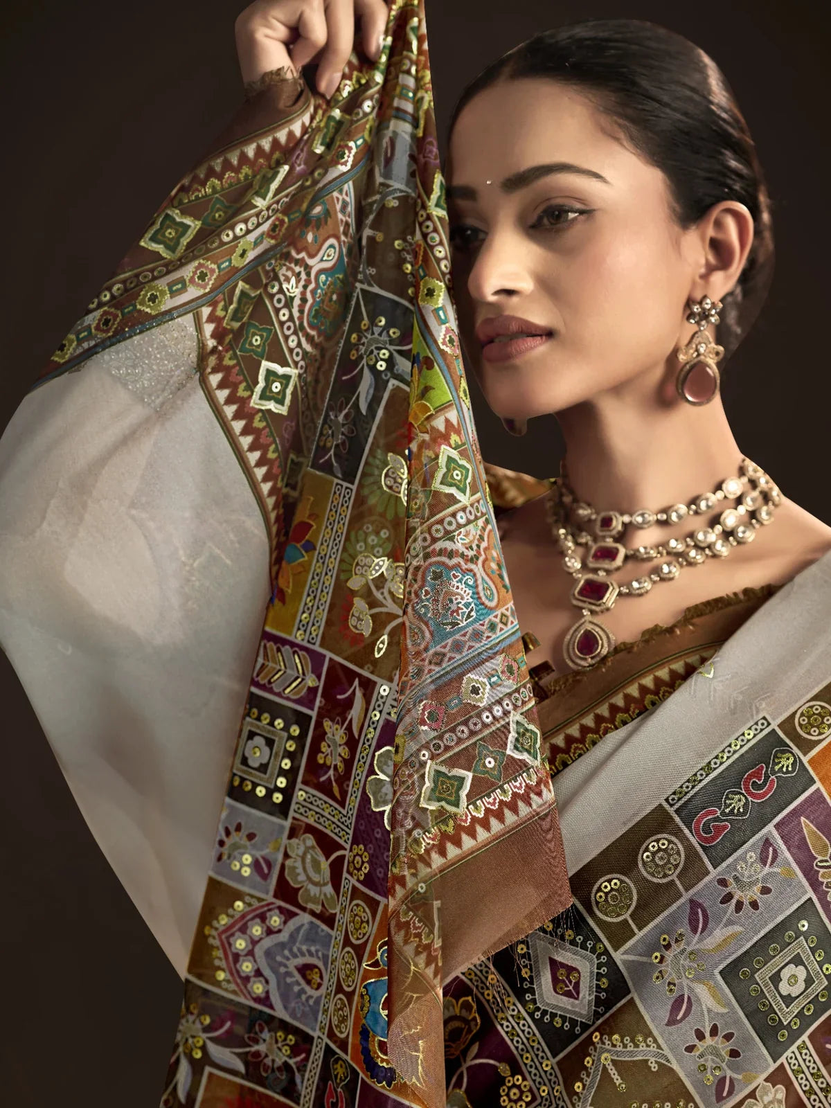 Tarani brown crepe silk saree closeup showing intricate foil printed motifs and elegant shimmer