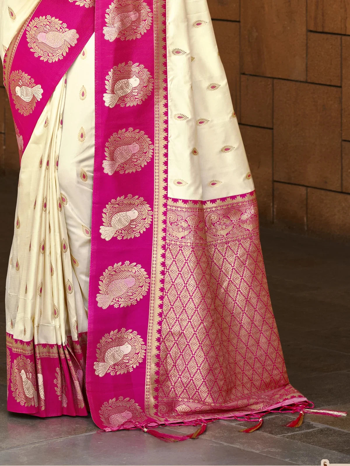 Tarani cream silk saree showing rich magenta zari pallu with peacock design close-up