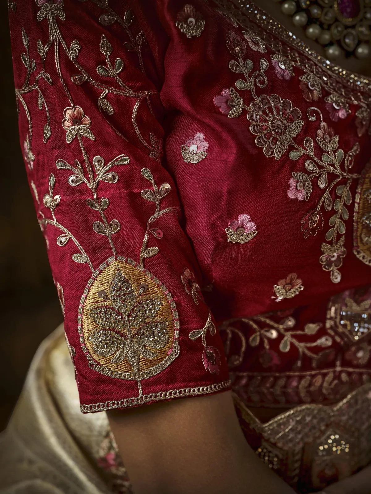 Tarani golden silk saree blouse closeup with rich maroon embroidery and zari work