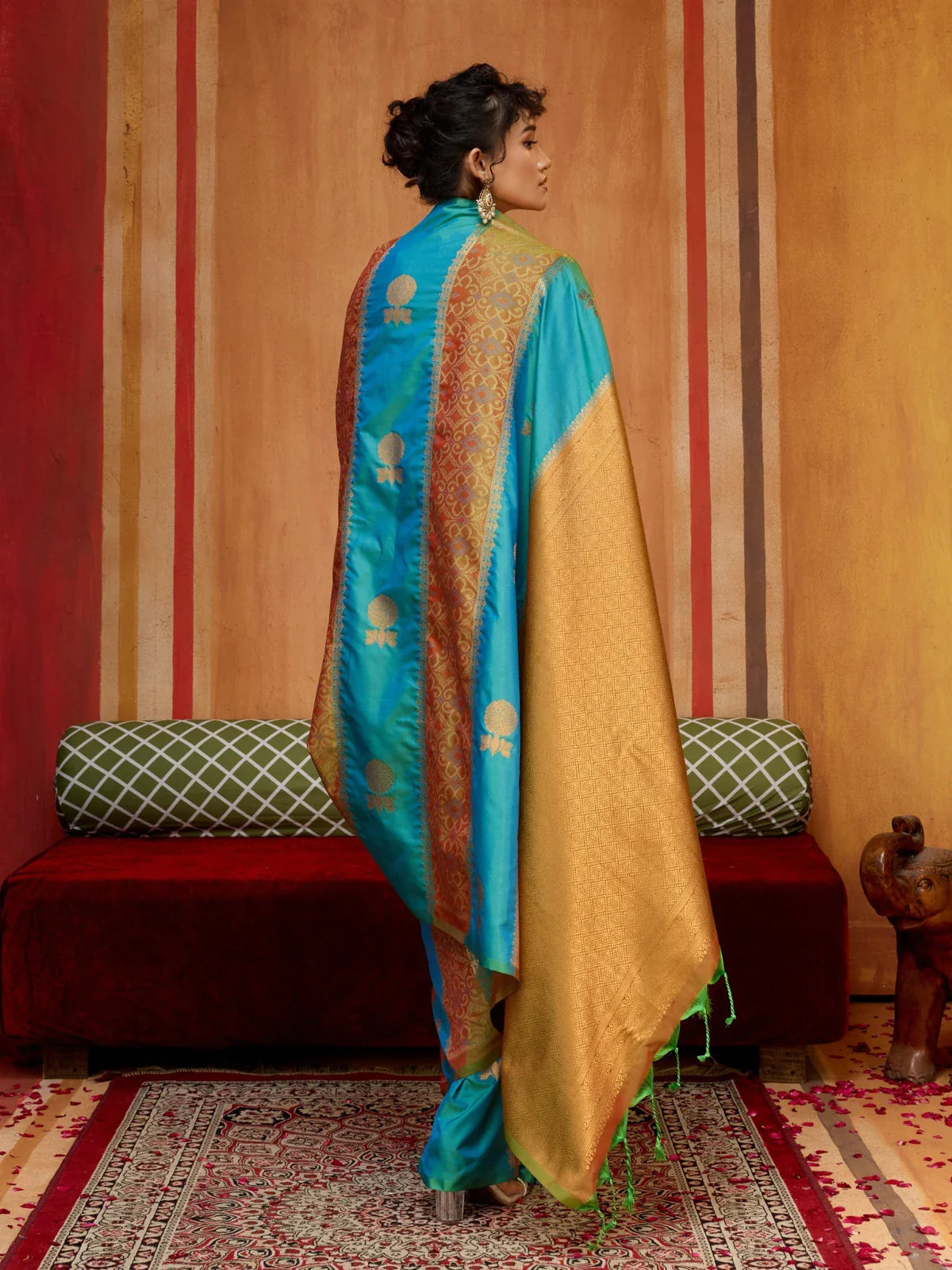 Tarani green silk saree back pose showing rich pallu and golden threadwork on soft fabric