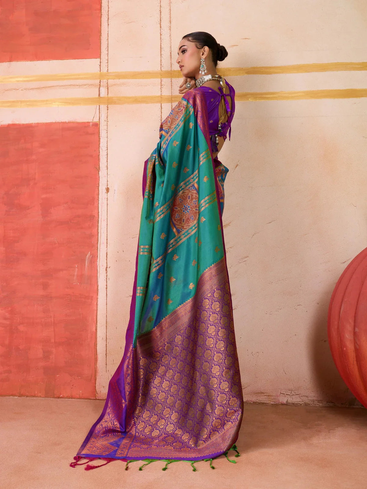Tarani green silk saree with detailed golden motifs and purple back pallu shown from rear angle
