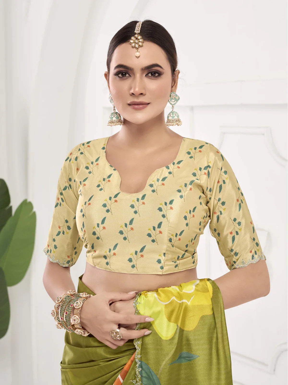 Tarani blouse design in yellow with floral embroidery paired with green silk saree close-up