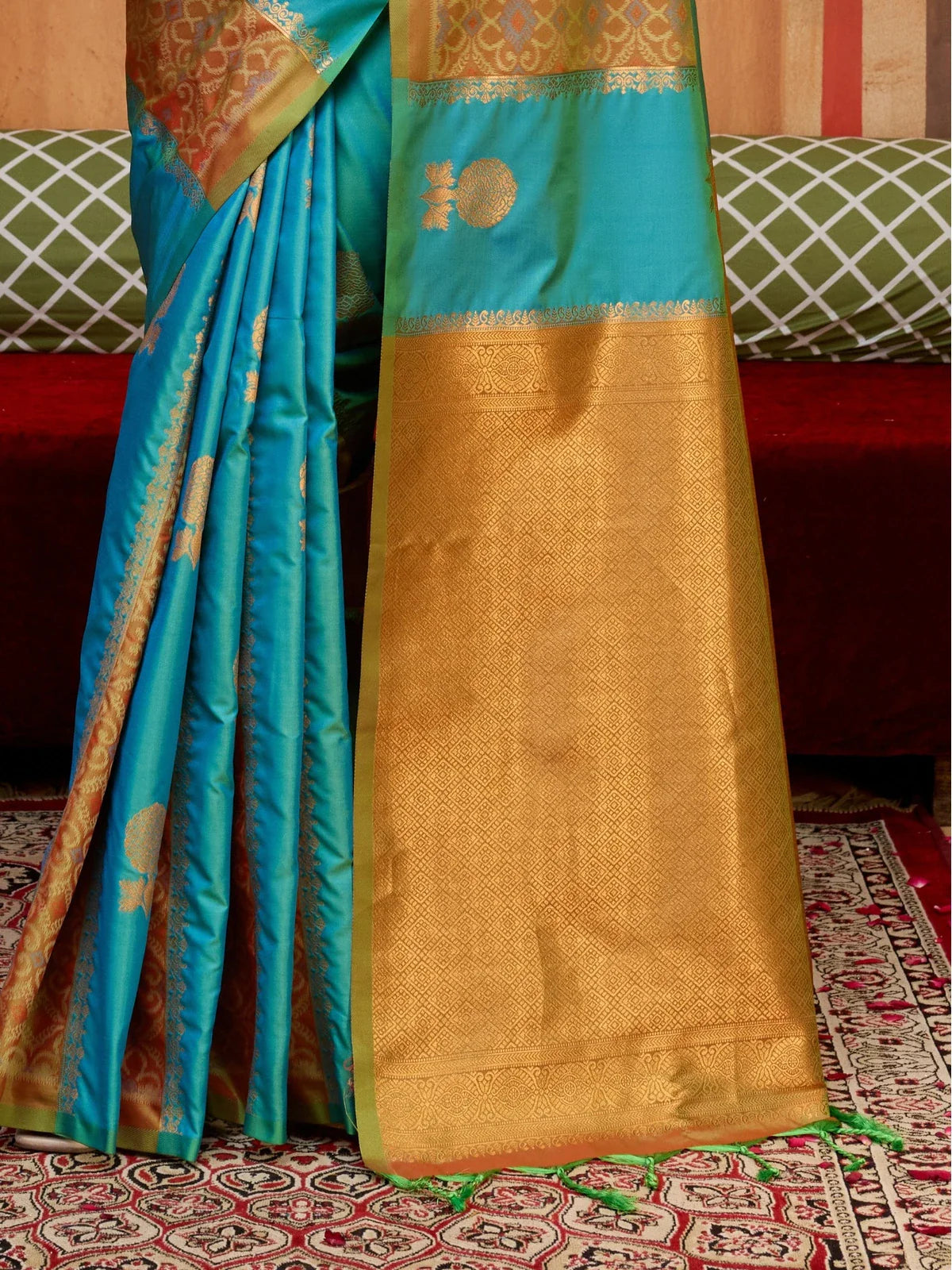 Tarani green silk saree pallu closeup with intricate golden zari detailing and elegant weaving