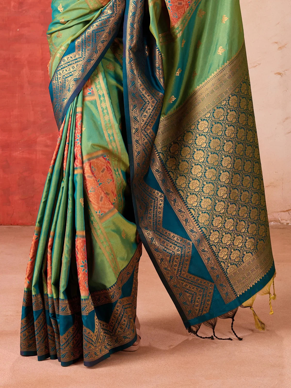 Tarani close-up of green woven saree border and golden detailing