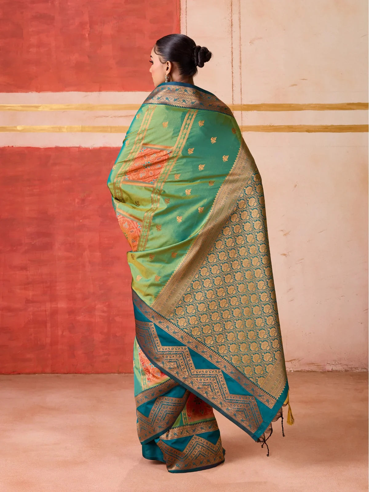 Tarani back view of premium silk green saree with traditional golden motifs