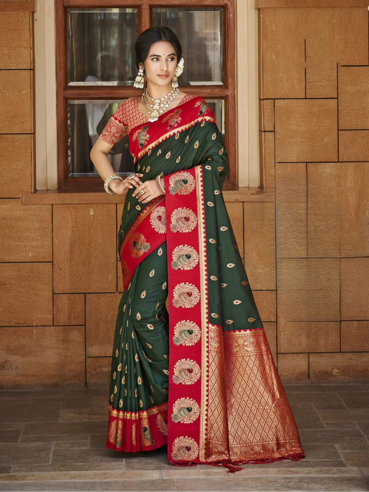 Tarani green silk saree with red border and golden zari pallu shown in full view with traditional styling