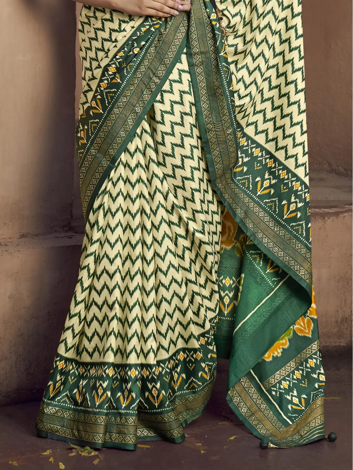 Tarani green silk saree pallu closeup highlighting intricate embroidery tassels and border work