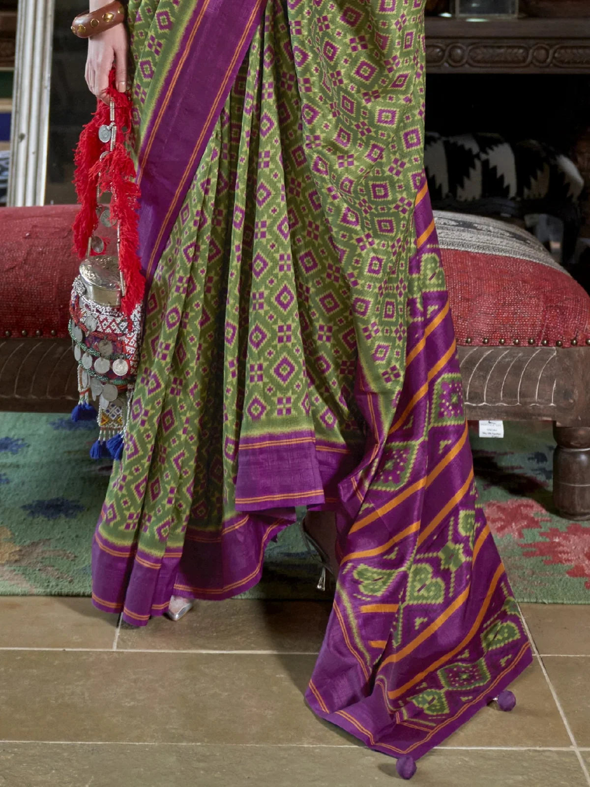 Tarani close-up green silk saree pallu with traditional purple border and ikkat design details