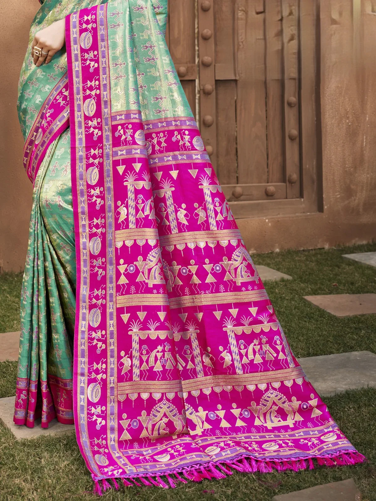 Tarani rich magenta pallu of green kanjivaram silk saree with golden warli motifs closeup