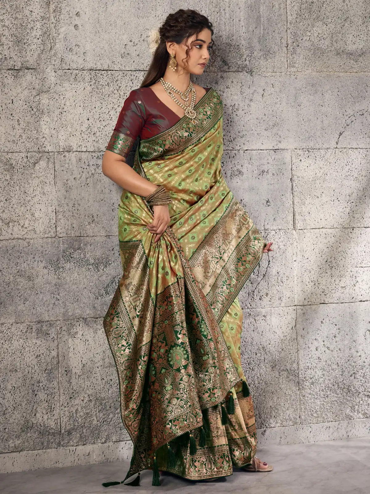 Tarani rich green Banarasi self embossed silk saree side view highlighting zari border and tassels